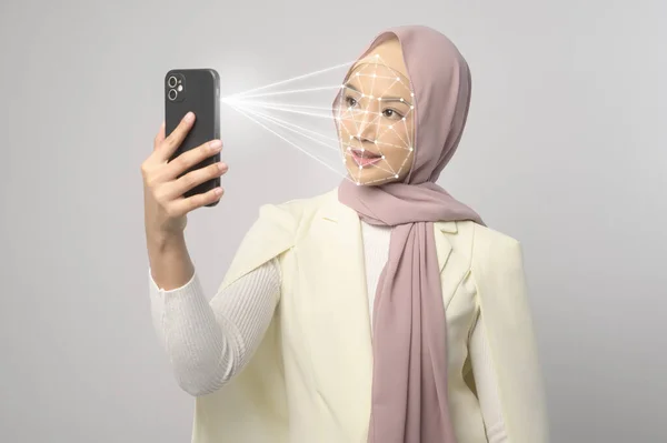 Beautiful woman is scanning her face with facial recognition system Smart phone