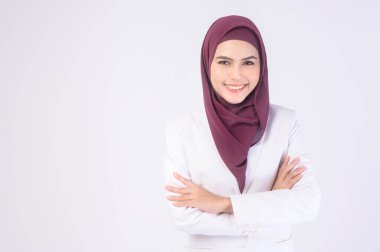 Stüdyoda tesettüre beyaz takım elbiseli güzel bir müslüman kadın.