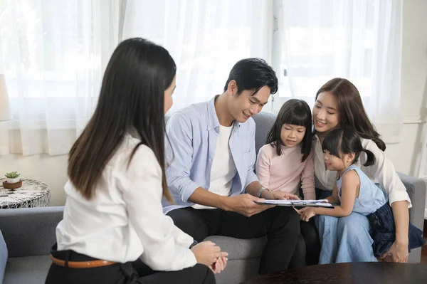 An Asian family meeting with female real estate agent or insurance consultant offering promotions , Mortgage, loan, property and medical health insurance concept.
