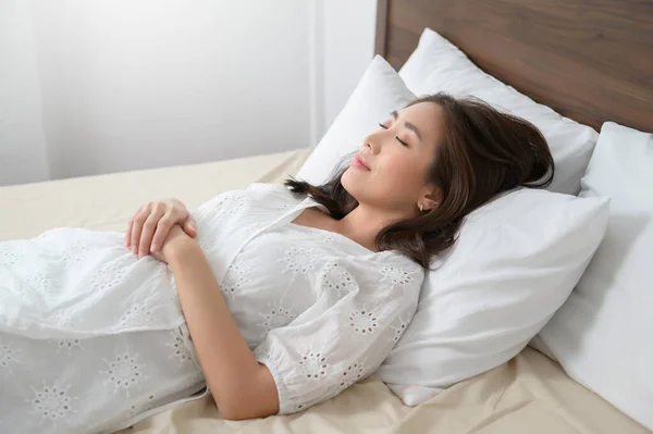 young asian woman sleeping on the bed in bedroom, happy healthy lifestyle concept