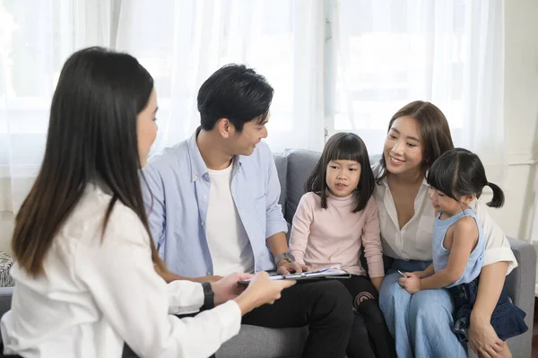 An Asian family meeting with female real estate agent or insurance consultant offering promotions , Mortgage, loan, property and medical health insurance concept.