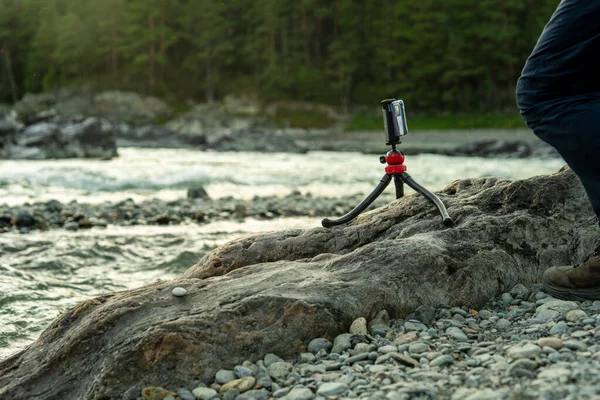Bir adam peyzaj fotoğrafçılığı için bir tripod kuruyor.