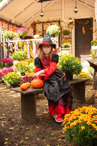 Boszorkánynak Öltözött Kislány Tökkel Ünnepli Halloweent Ősszel Kertben Ház Közelében — Stock Fotó