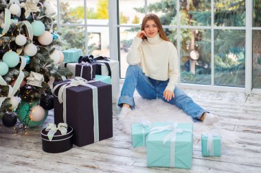 Noel arifesinde hediyeleri olan güzel bir genç kadın. Metin için yer, şenlikli arkaplan