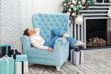 Noel, mutluluk konsepti. Bir sürü hediye kutusuyla gülümseyen kadın. Noel ağacının arka planındaki kız. Mutlu genç bayan Noel 'i kutluyor.