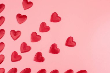 red hearts on a pink pastel background. Abstract background with paper-cut shapes. Sainte Valentine, mother's day, birthday greeting cards, invitation, celebration concept