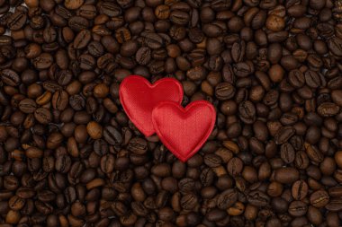 red heart and an inscription of letters on a background of coffee beans. Love coffee concept. St. Valentine's Day. View from above.