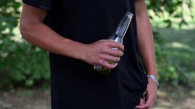 Yazın açık havada bira içen genç bir adam. Kötü alışkanlıklar ve sağlıksız yaşam tarzı kavramı.