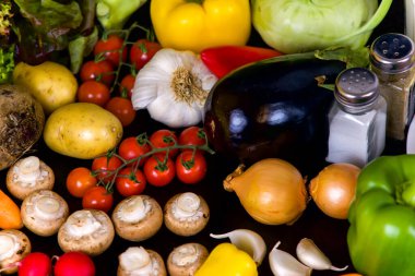 Sebze ve diyet yemekleri siyah arka planda, üst tarafta, düz alanda.