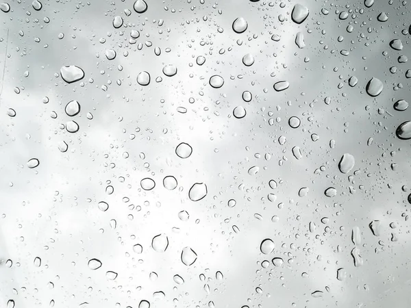 Cama yağmur damlaları yağdı. Seçici odaklanma. Beyaz gri bulutlar arkaplan deseni dokusu.