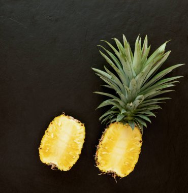 Siyah desenli arka planda ananas. Bir sürü lif, C vitamini ve mineraller var. yiyecek, meyve veya sağlık hizmeti kavramı.