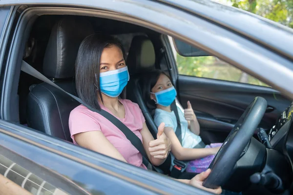 Family vacation holiday, Coronavirus Covid-19 and face mask, mother wearing fabric face mask for kid girl daughter when. new normal stay safe. summer ride by automobile.