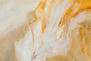 Yerde güzel turuncu dokular, yüksek bir yerden manzara, eski bir taşocağı su basmış. Kumdaki paslı ayak izleri. Arkaplan