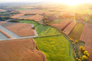 Güneşin parlak ışıklarıyla aydınlatılan, yaz manzarası, sarı-yeşil tarlaları olan sulu parlak tarlalar.