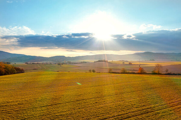Beautiful summer landscape, green fields, trees and the setting sun against the blue sky. Poland, Klodzko