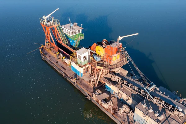 Büyük bir kova ve taşıma bandıyla yüzen bir platform okyanusun dibinden kum çıkarıyor. Okyanusun dibinden kumun çıkarılması. Hava fotoğrafçılığı