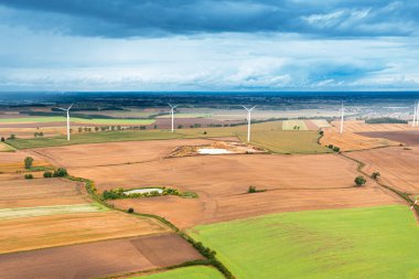 Tarlaların ve ormanların üzerinde gök gürültülü bir bulutla kaplı yaz manzarası, yukarıdan görünüyor.