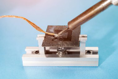 Yeniden başlatmadan önce işlemciyi hazırlıyorum. Levye ve bakır örgü kullanarak fazla kalay bilgisayar işlemcisinden çıkarılıyor