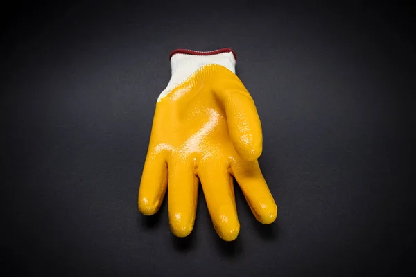 Yellow protective gloves for construction and cleaning on a dark background