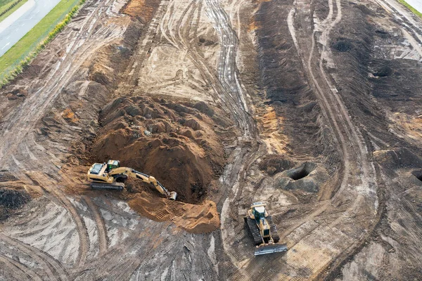 挖掘机在地基下挖一个壕沟 推土机清理地面 建筑工地的俯视图 — 图库照片