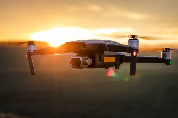 Gün batımında dijital kamerayla uçan insansız bir kuadkopter. Gün batımında drone silueti