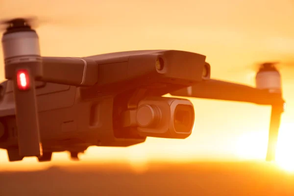 Gün batımında dijital kamerayla uçan insansız bir kuadkopter. Gün batımında drone silueti