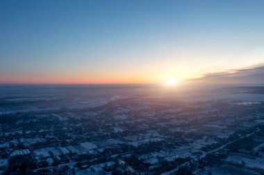 Köyün manzarası yüksekten, akşamları parlayan küçük özel evlerden, kış günbatımından