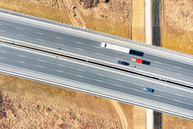 Yukarıdan otoyol manzaralı, yoldan geçen arabalar, otoyolda giden kamyonlar.