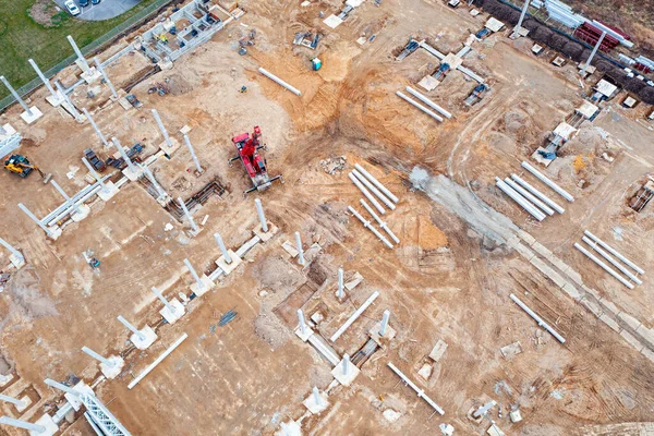 İnşaat alanındaki temel ve beton kolonların üst görüntüsü, endüstriyel binaların inşası, inşaat sahasında vinç