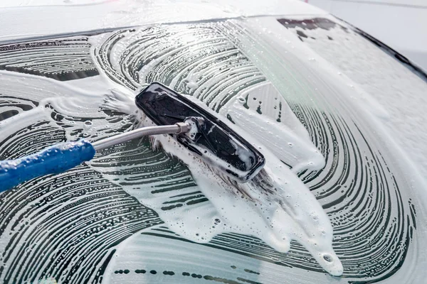 Chemical detergent for car cleaning. Car in white foam. car wash.