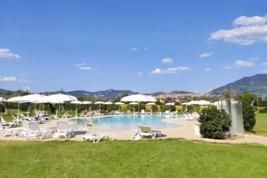 Sıcak bir yaz gününde, sahilde havuz kenarında dinlenen bir sürü güneşli gün.