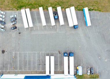 Depolu bir lojistik parkının hava görüntüsü, karavanlı kamyonlar bir otoparkta duruyor ve yükleme ve boşaltma için bekliyorlar.