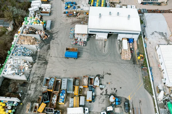 Aerial view of industrial buildings and waste processing plant, many garbage containers, sorting and further processing of metal, dirty industrial areas of the city from a high altitude
