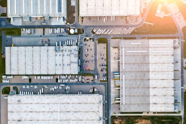 Bir deponun havadan görüntüsü. Karavanlı kamyonlar, bir lojistik deposunun yakınındaki bir otoparkta, bir çevrimiçi mağazanın depolarında, bir sanayi bölgesinde, büyük bir yükseklikten manzaralı bir yerde duruyorlar.