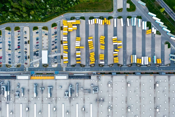 Aerial view of a warehouse. Trucks with trailers stand in a parking lot near a logistics warehouse, warehouses of an online store, an industrial zone, a view from a great height