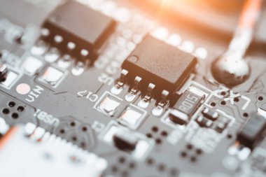 Elektronik devre kartı parlak ışıkla aydınlatılmış.
