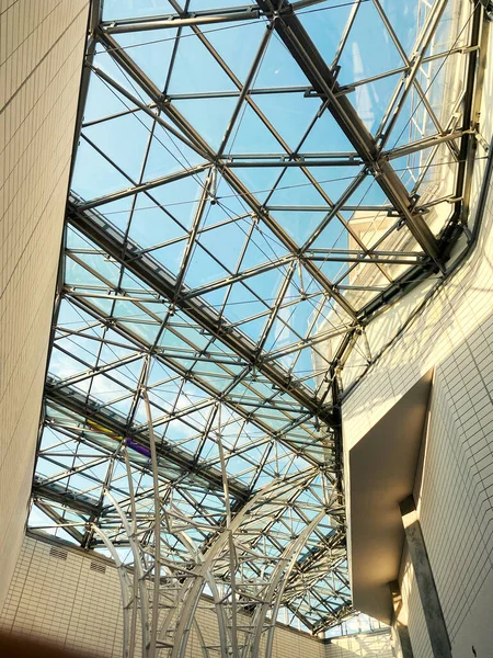 Geometric metal structure with glass, ceiling in a shopping center against the sky