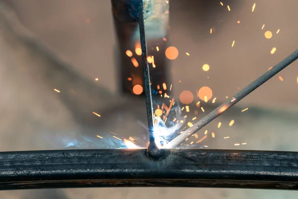 Welding close-up, a lot of sparks and smoke from electronic welding, industrial area