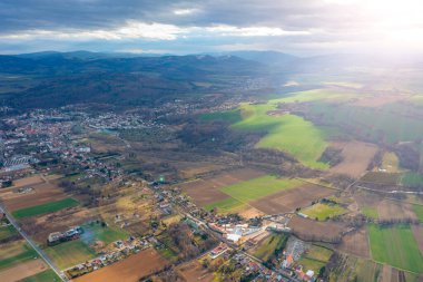 Dağın eteğindeki küçük bir Polonya kasabası. Küçük evler ve bir kilise. Ignor tarlalarında kuş bakışı manzara