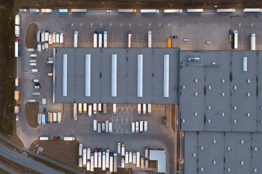 Aerial view of a warehouse with goods. Logistics center in the industrial zone of the city, many trucks are waiting for loading in the logistics warehouse