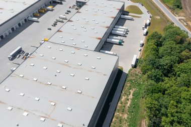 Aerial view of a large logistics warehouse, an online store warehouse, a lot of trucks waiting for loading in the parking lot