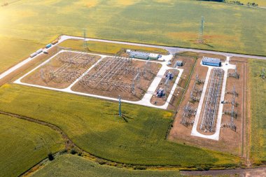 Aerial view of a large high voltage distribution substation in Poland. Lots of electrical transformers and a pole with power lines