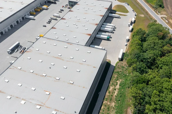 Aerial view of a large logistics warehouse, an online store warehouse, a lot of trucks waiting for loading in the parking lot