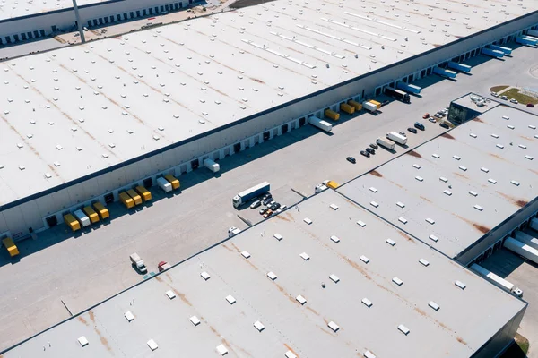 Aerial view of a warehouse of goods. Logistic warehouse buildings and many trucks loading goods