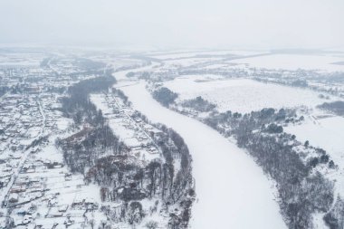 Aerial view of a frozen river. The river is frozen and covered with snow, severe frosts