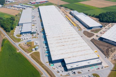 Aerial view of a warehouse of goods. Logistic warehouse buildings and many trucks loading goods