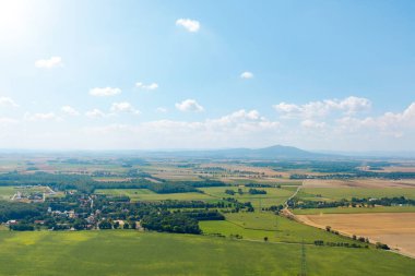 Rural landscape, green fields and small mountains in the background