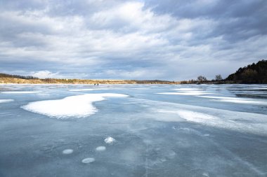 Winter landscape on a frozen river at sunset, heavy frost and a frozen river in winter, everything is covered with snow