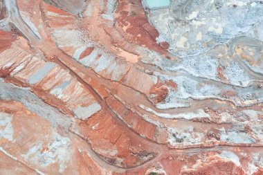 Aerial view of the quarry, beautiful orange patterns and overhanging rocks in a copper-magnesium quarry