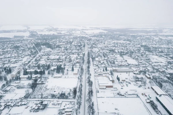 View from a height of a small village in winter. Snowy village, snow-covered houses and roads. February weather in Ukraine